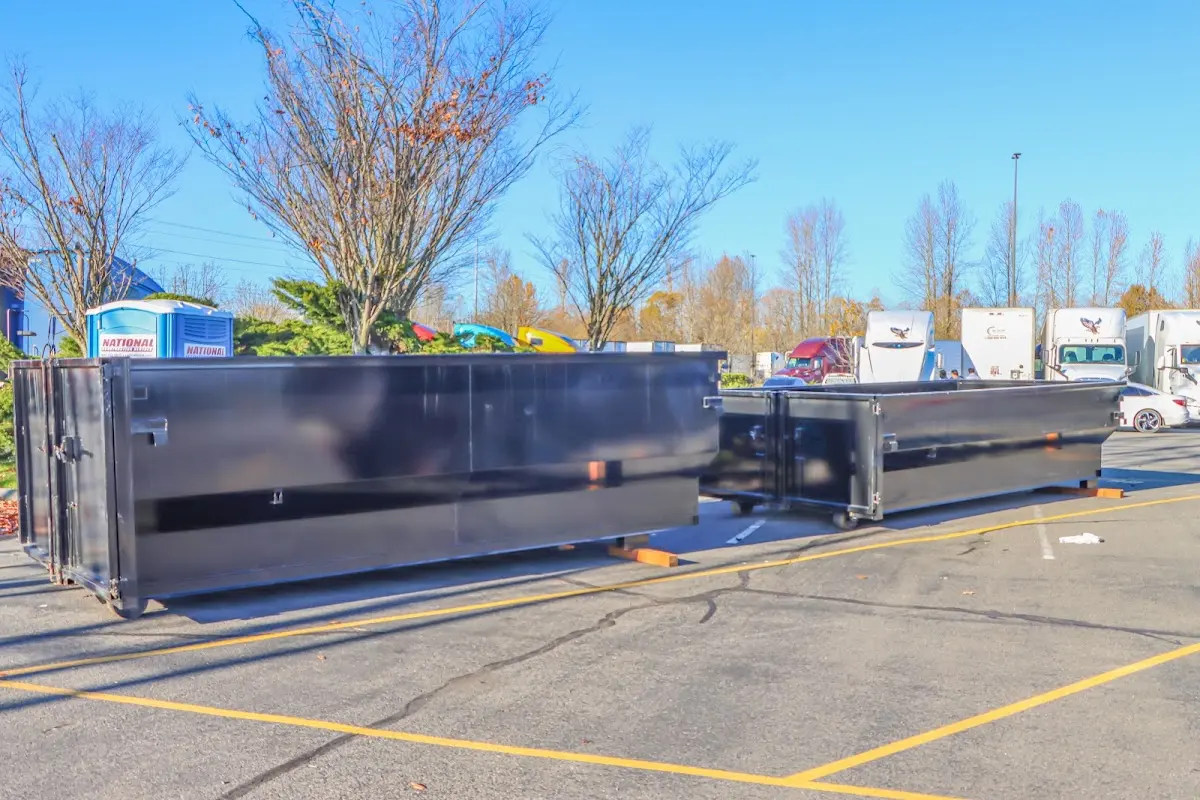 Professional dumpster rental service with roll-off container on residential driveway in Blackwell